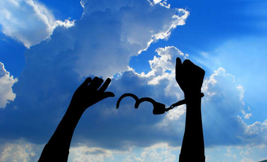 arms up in the air with one hand freed from handcuffs