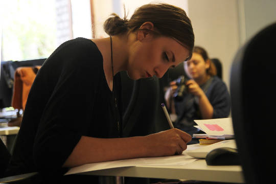 Don’t Give Up Before You Begin woman sitting at a desk working while someone in the background is not working