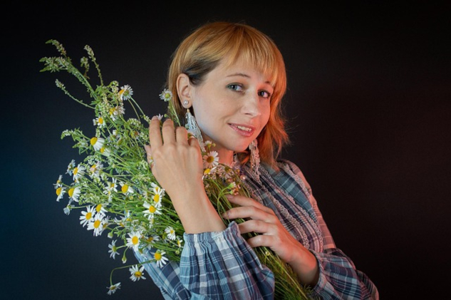 A young woman holding a bunch of wild flowers.&nbsp;Image by Victoria from Pixabay. 